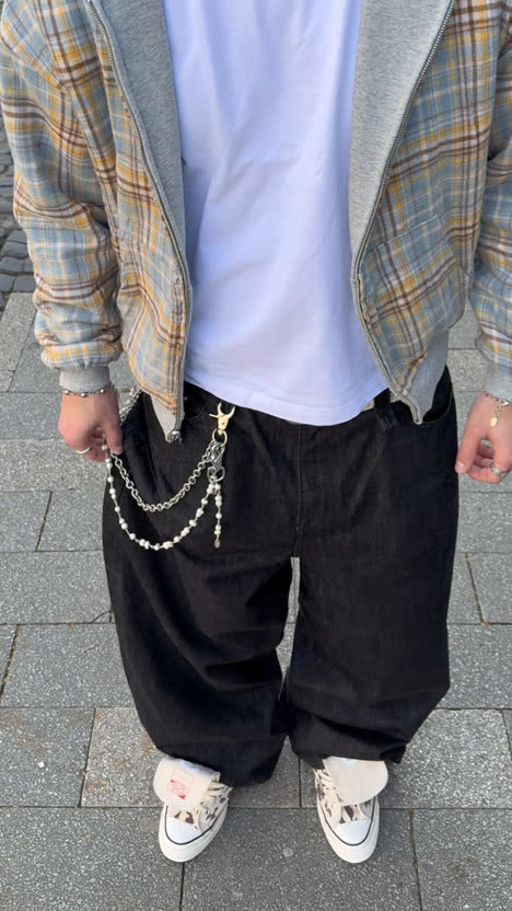 First frame of the analysed post: a streetwear outfit photographed chest-down on a cobblestone street.