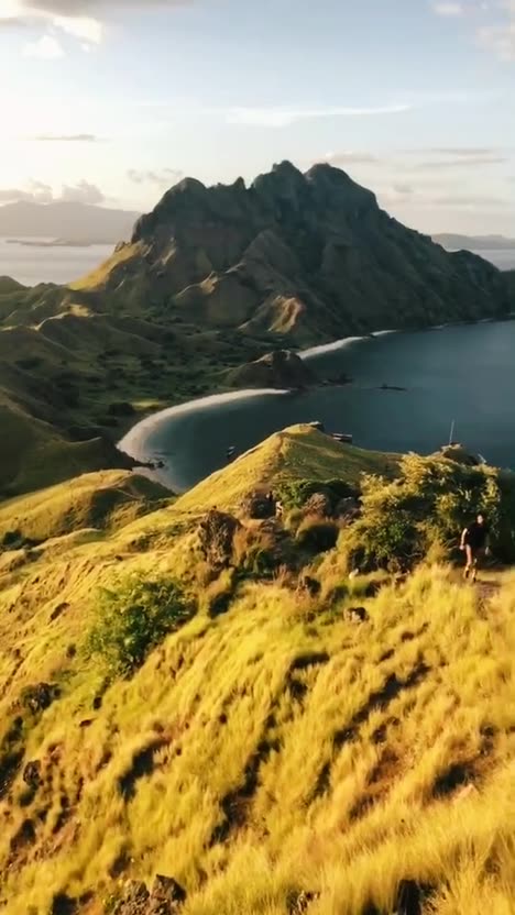 First frame of the analysed post: an aerial shot of a green island ridge above the sea at sunset.